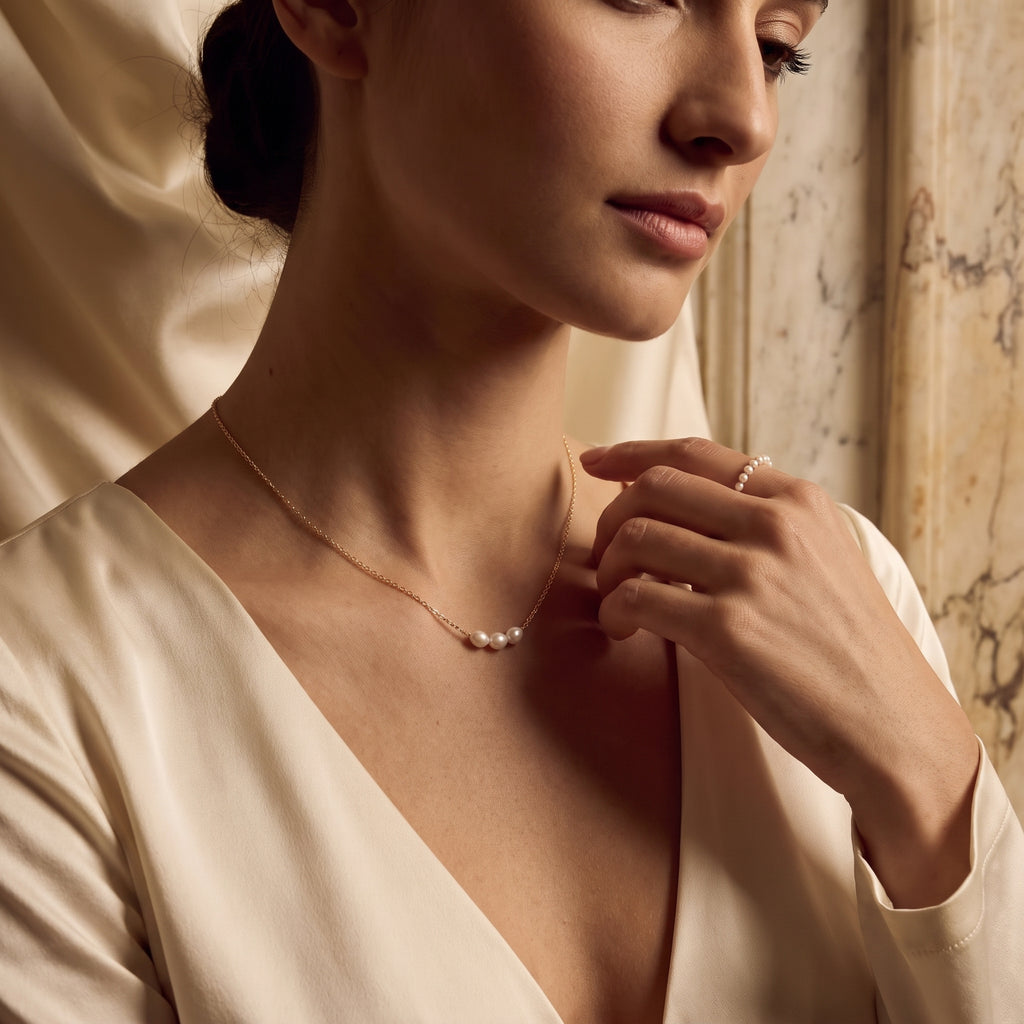 Three pearl gold necklace worn by woman